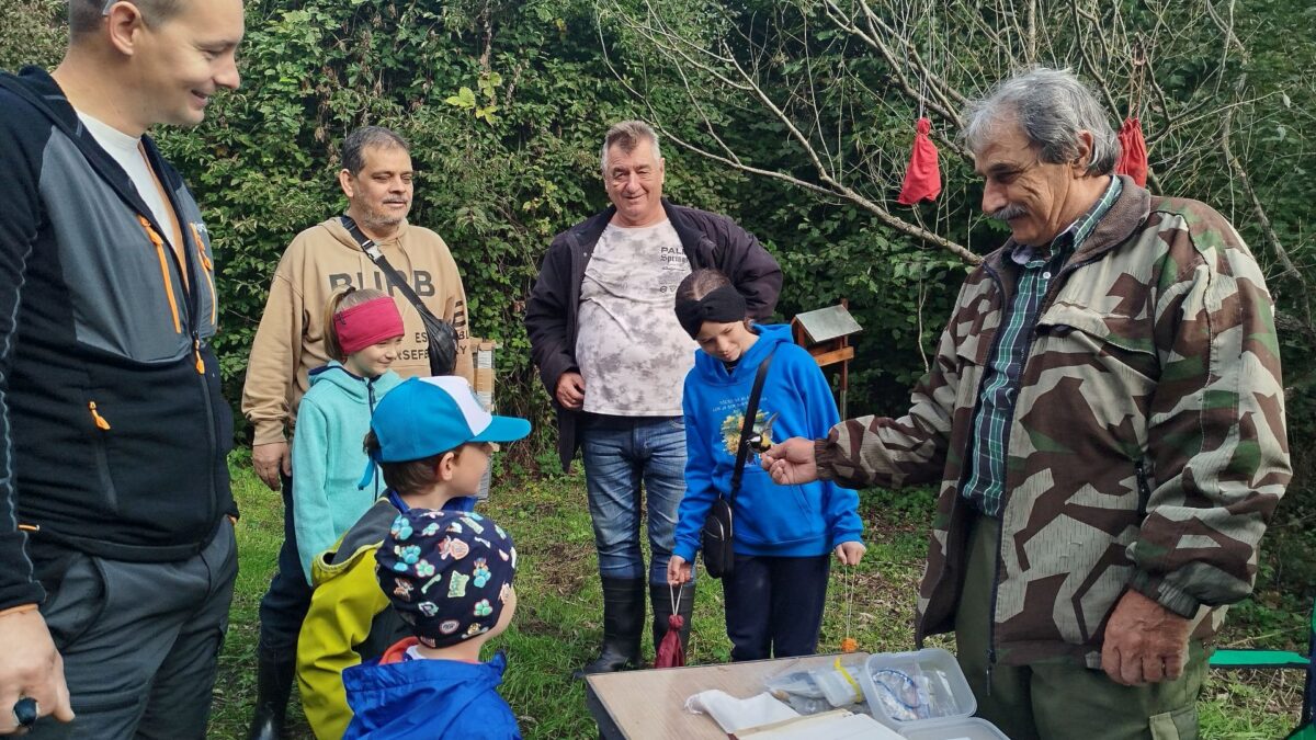 skupina ľudí stojacich okolo stola v lese